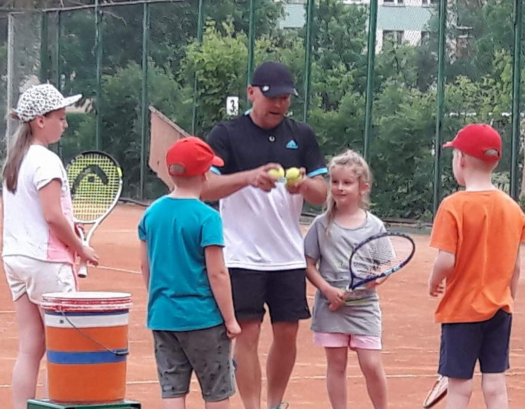 panu uczy dzieci grać w tenisa